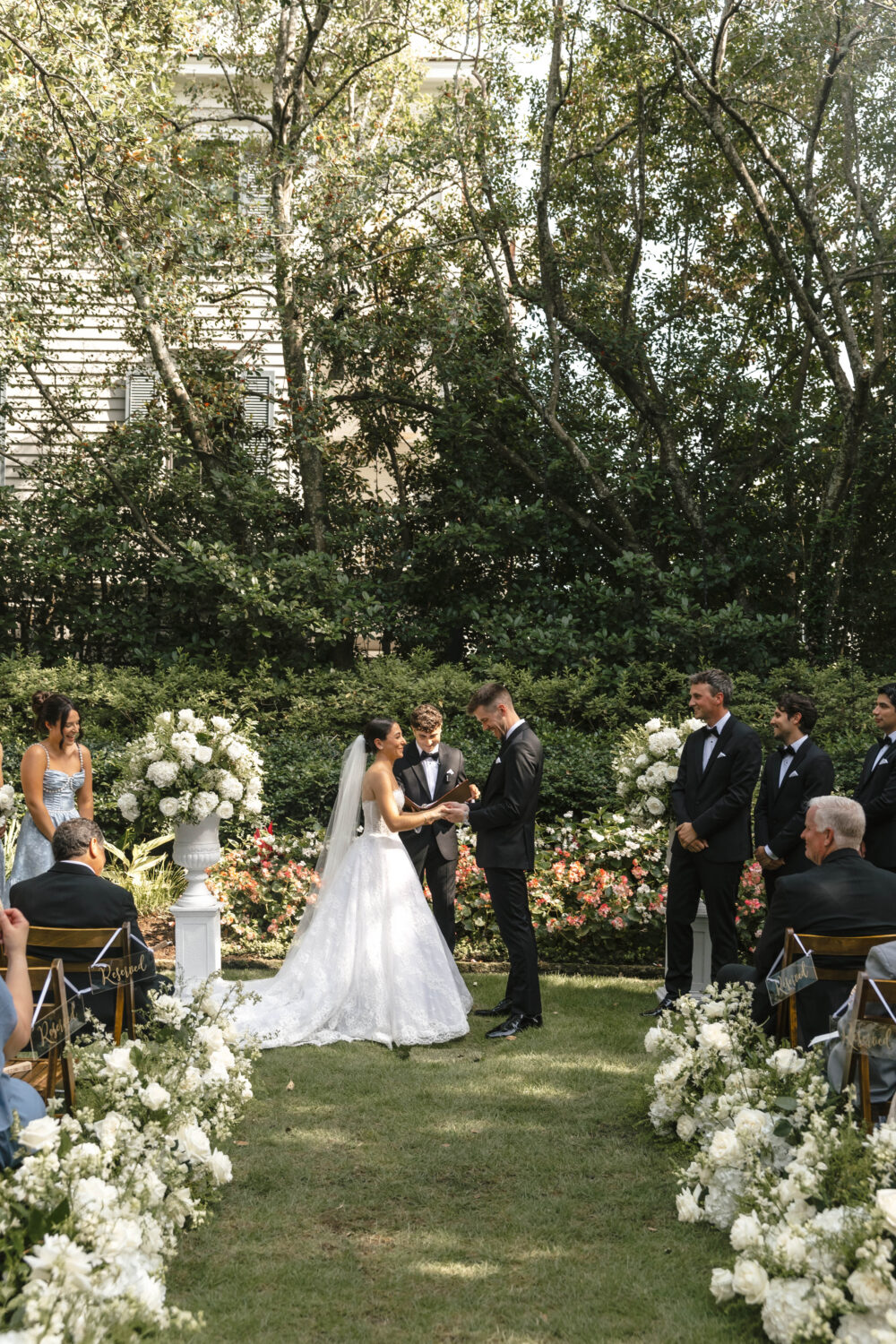 lush wedding ceremony lawn with floral arrangements lining the aisle