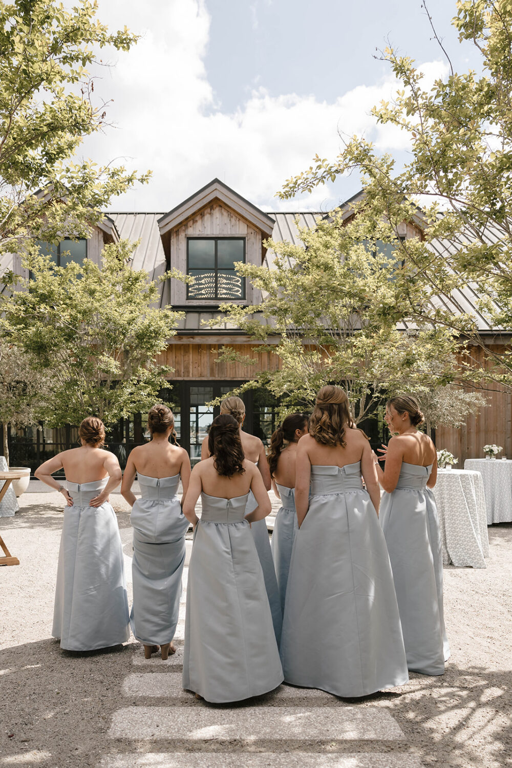 bridesmaids in matching blue dresses walking towards The Dunlin wedding venue entrance