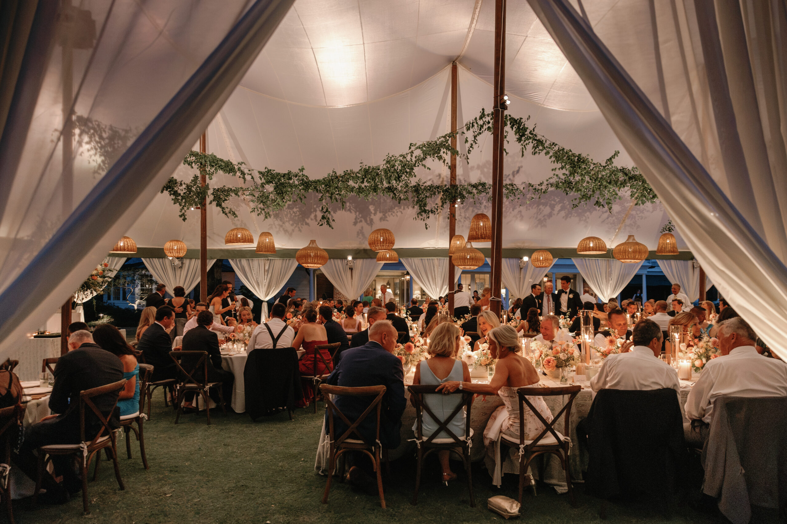 Wedding guests eat dinner by candle light at Yeaman Hall Club